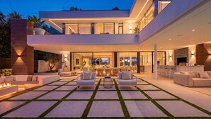 A modern house with a spacious outdoor area featuring a fire pit, seating, and a dining area. - Villa Almost Heaven by Vacation Marbella (Nueva Andalucía)