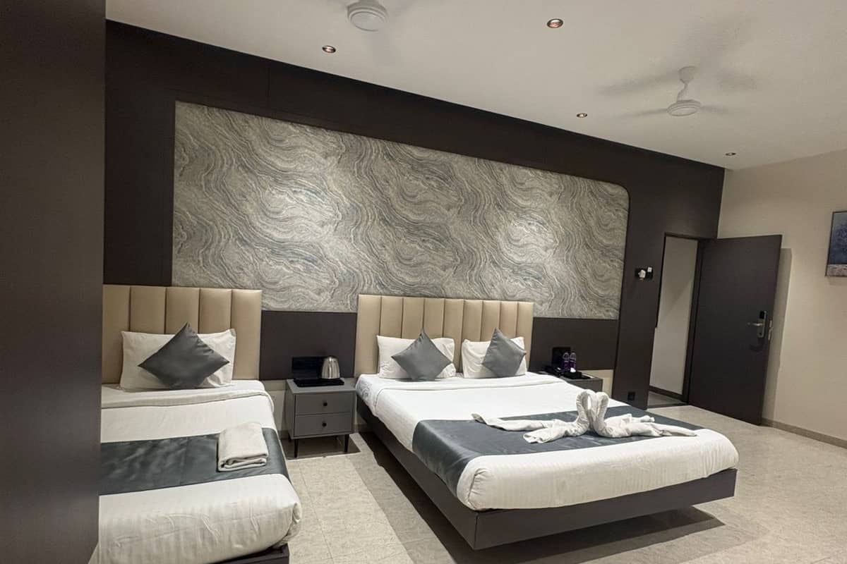 Ein modernes Hotelzimmer mit zwei Betten, einem großen Wandbild und einem Deckenventilator.