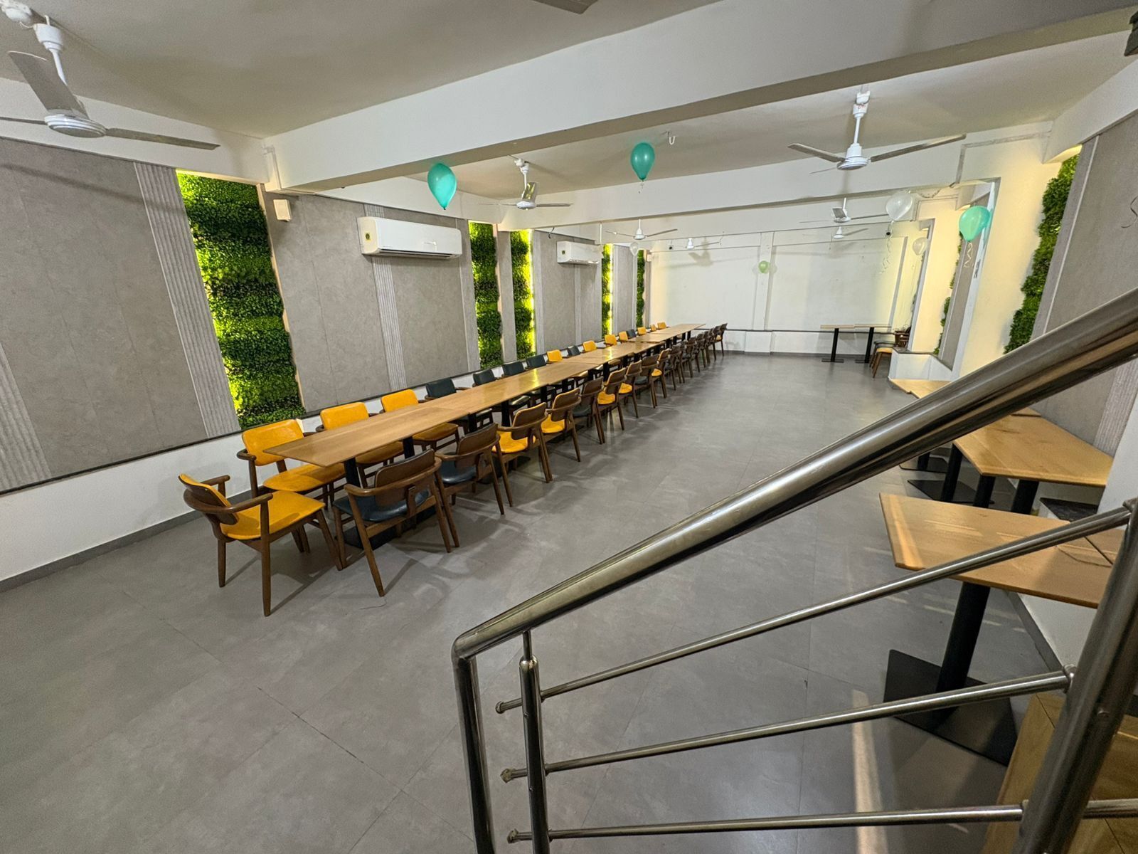 Une salle de conférence avec une longue table, des chaises et un escalier.