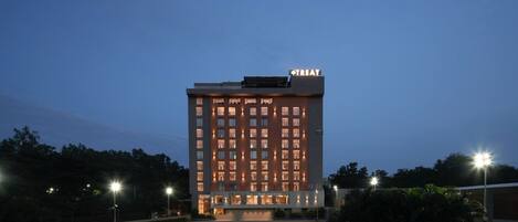 A multi-story hotel with a flat roof and a sign reading "TREAT" at the top.