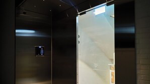 An elevator interior with a control panel, a handrail, and a tactile paving floor. - Dandelion Sinsa Branch 1 (Seoul)