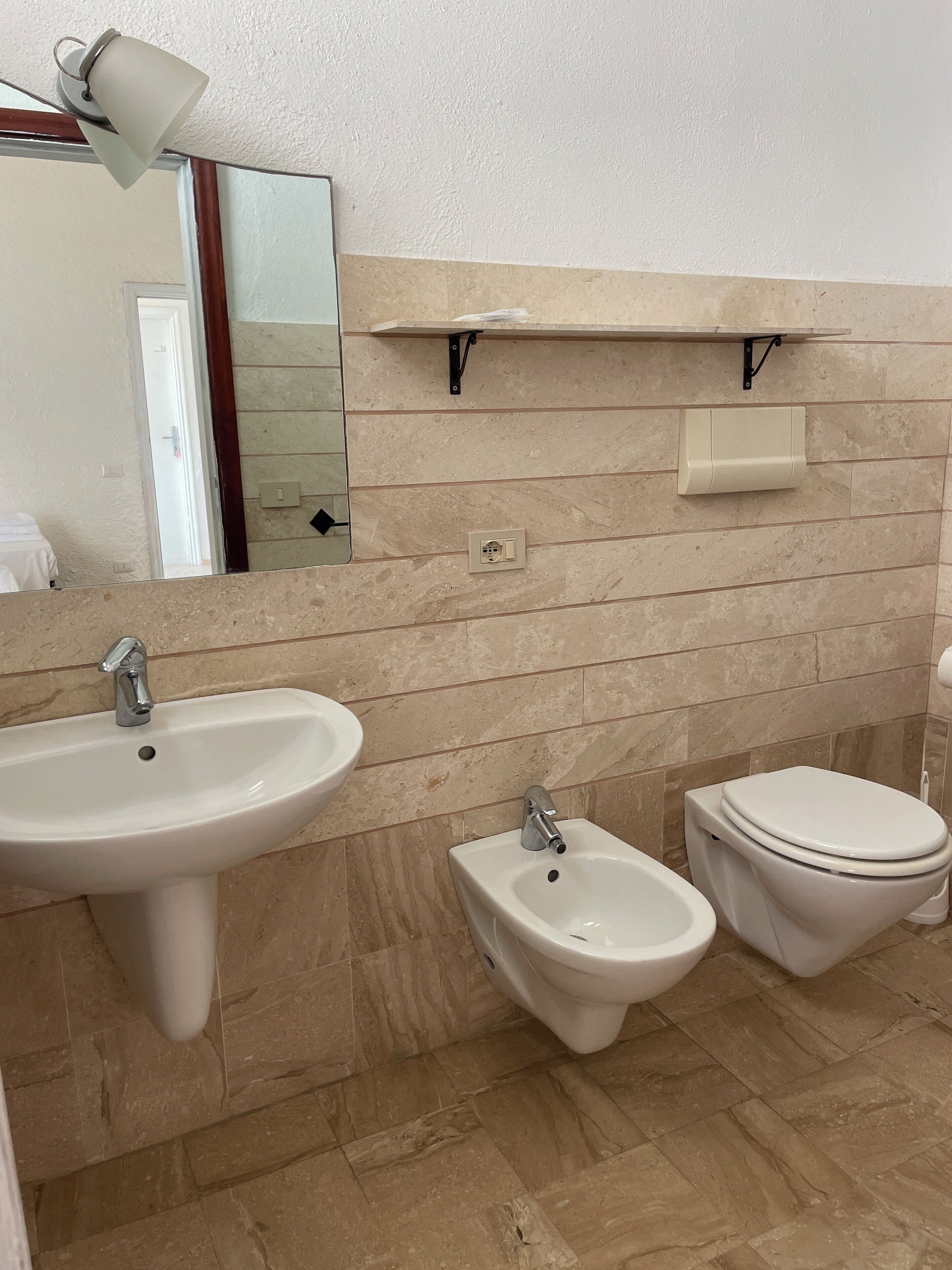 Une salle de bain équipée d’un lavabo, d’un bidet et de toilettes.