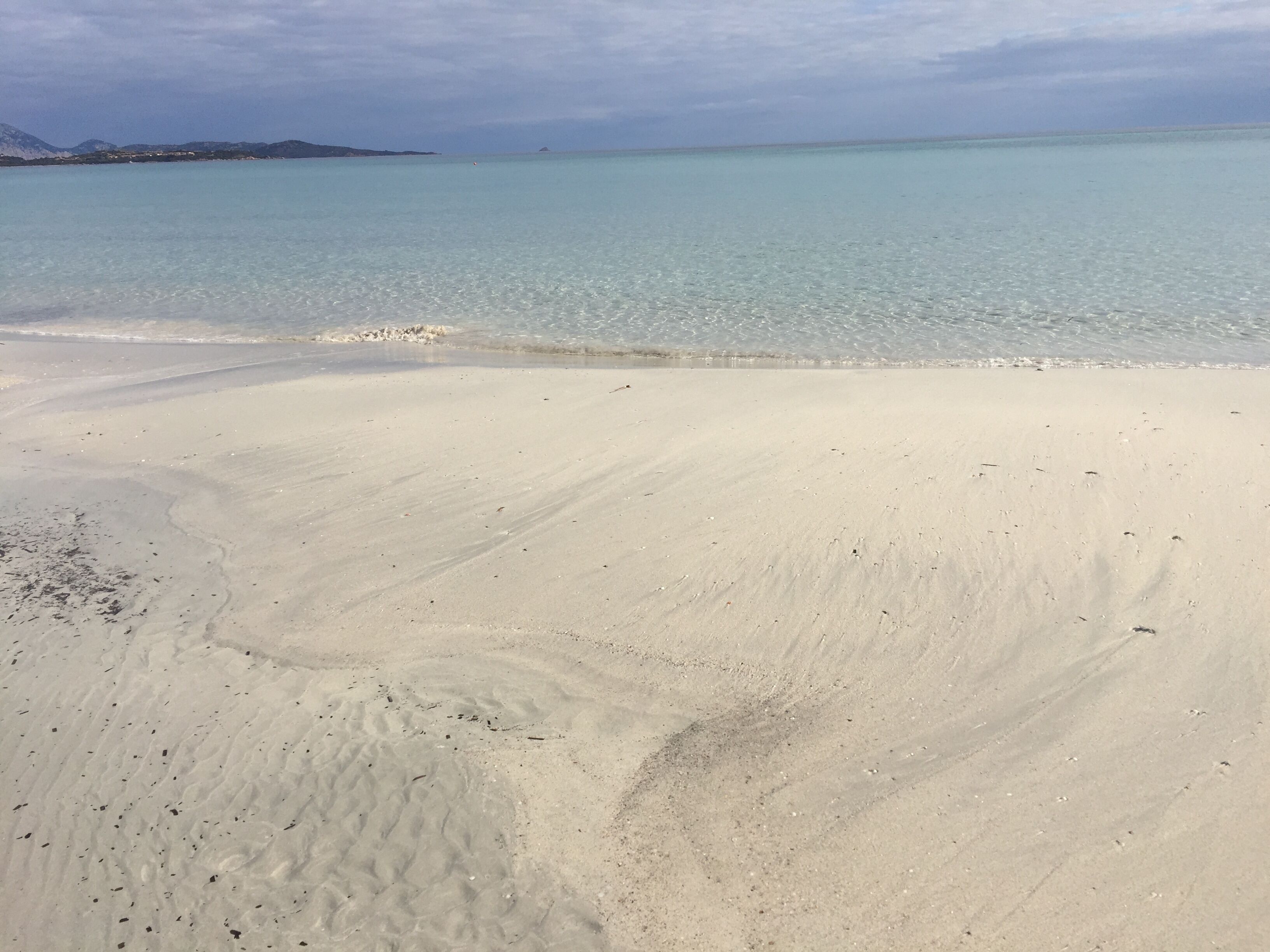 A beach with clear turquoise water and white sand.