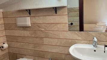 Un baño con bidé, lavabo e inodoro.