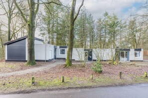 A modern building with a grey exterior and a small attached structure. - Veluwe Forest Bungalow (Kootwijk)