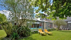 A modern house with a glass-enclosed patio, a swimming pool, and outdoor seating. - La belle étape by Interhome (Cherrueix)