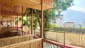 An outdoor seating area with bamboo railings and a view of a body of water.