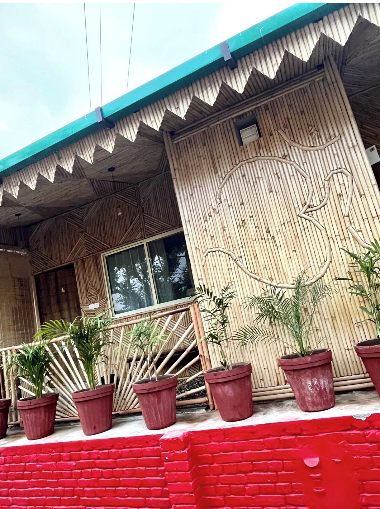 A building with a distinctive zigzag roof and bamboo wall panels.