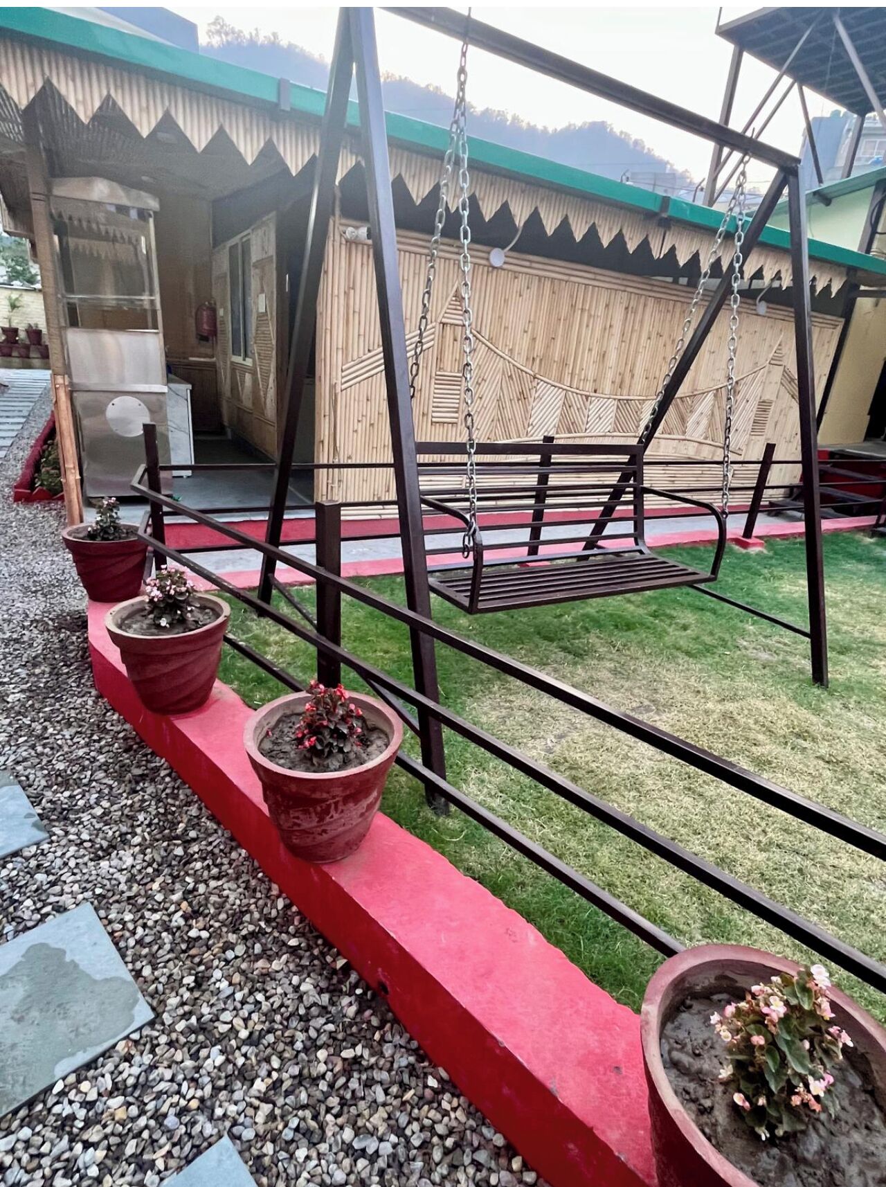 A swing set with a metal frame and a red platform.