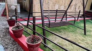 A swing set with a metal frame and a red platform.
