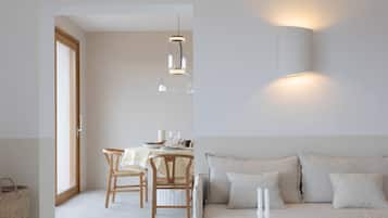 Un intérieur moderne comprenant un coin repas, un canapé et un luminaire fixé au mur.