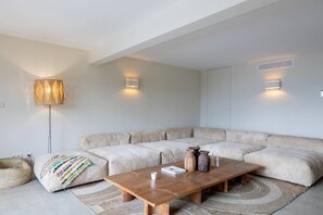A modern living room with a sectional sofa, a wooden coffee table, and a floor lamp.