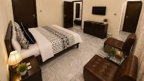 A modern bedroom with a bed, bedside table, lamp, and a TV mounted on the wall.