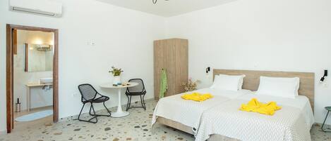 Ein Schlafzimmer mit einem Bett, einem Sessel, einem kleinen Tisch, einem Spiegel und einem Holzschrank.