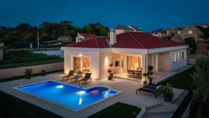 A modern house with a swimming pool, a patio with outdoor furniture, and a stone fireplace. - Villa Eleni ZadarVillas (Ljubač)