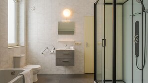 A modern bathroom with a glass shower enclosure, a toilet, a bathtub, and a vanity with a mirror. - Reevallis Holiday House, Vijlen (Vijlen)