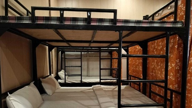 A bunk bed room with two beds, each with white bedding and pillows. - High Class Bhojnalaya and Dormitory (Varanasi)