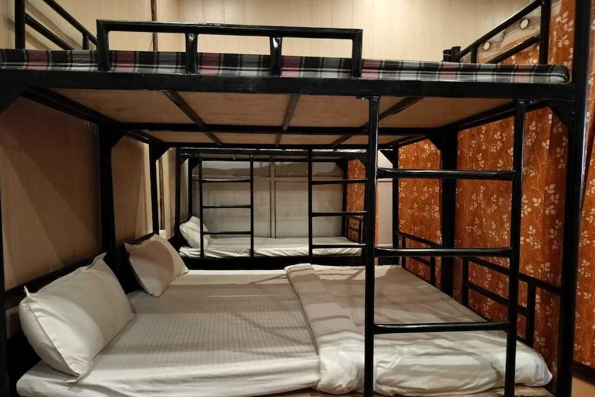 A bunk bed room with two beds, each with white bedding and pillows.