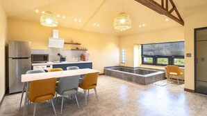 A modern kitchen with a dining area, built-in appliances, and a large window. - Jeju Pyeongdae 41street Pension (Jeju City)