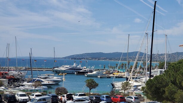 A marina with multiple yachts docked, a bridge in the background, and a coastal town across the water. - LE CAPITOLE, Sea view, Studio cabin 27m2 waterfront, 2 adults, 2 children, air conditioning and garage (Fréjus)