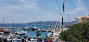 A marina with multiple yachts docked, a bridge in the background, and a coastal town across the water. - LE CAPITOLE, Sea view, Studio cabin 27m2 waterfront, 2 adults, 2 children, air conditioning and garage (Fréjus)