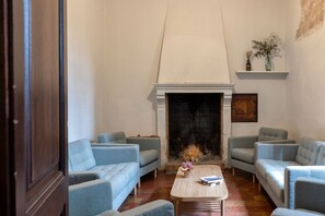 A living room with a fireplace, two sofas, a coffee table, and a bookshelf.