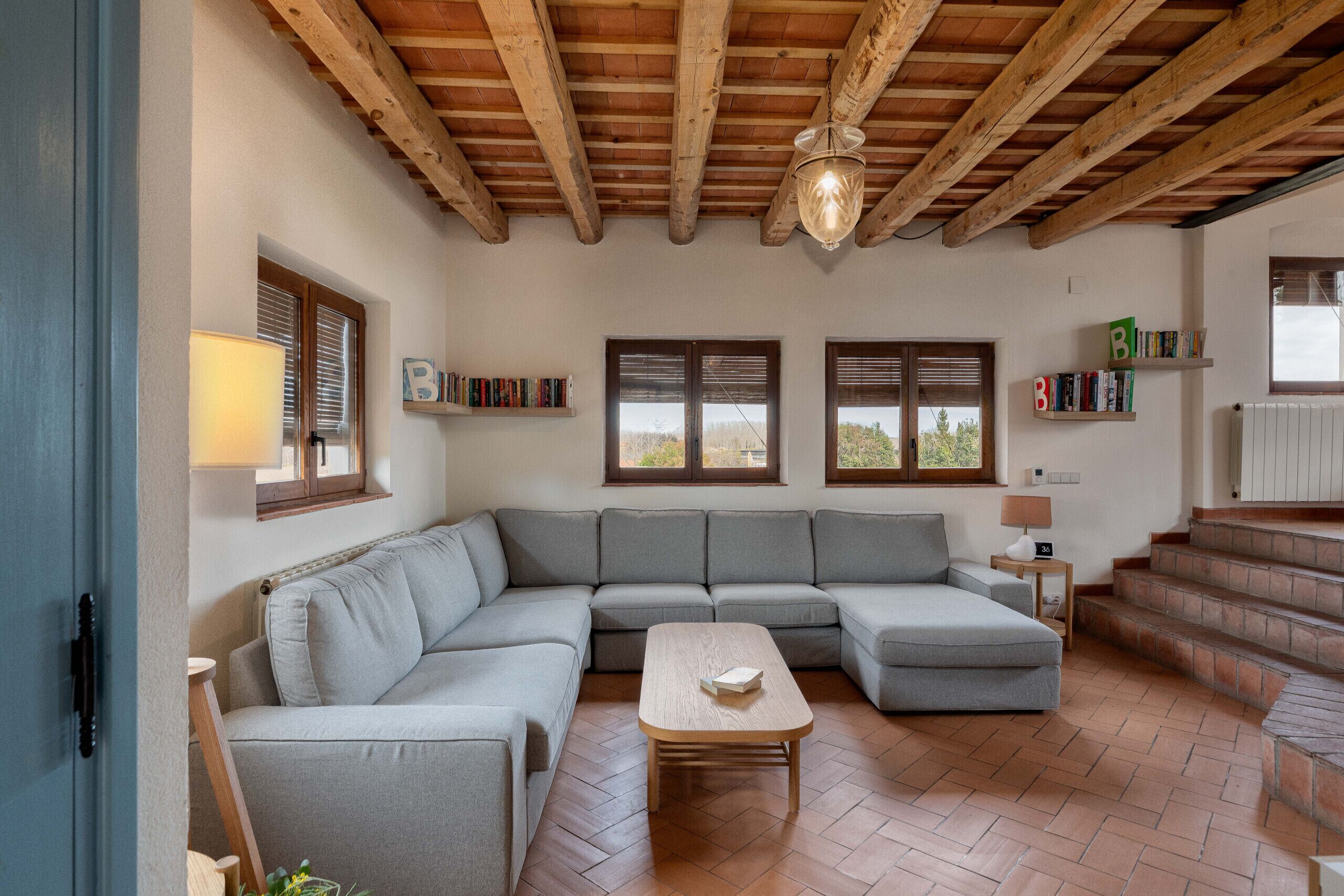 A living room with a sectional sofa, a wooden coffee table, and a herringbone-patterned floor.