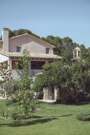 A two-story house with a tiled roof, a stone chimney, and a small bell tower. - Flateli. Casa Oliver (Cervià de ter)