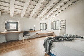 A bedroom with a lofted desk, a bed, and a window. - Flateli. Casa Oliver (Cervià de ter)