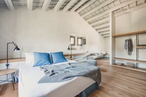 Quarto com uma cama grande, uma escrivaninha e um guarda-roupa.