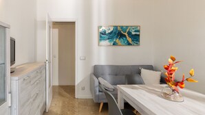 A modern room with a grey sofa, a wooden table, and a decorative vase. - Flateli. PDA Vista Mar 2 (Platja d´Aro)
