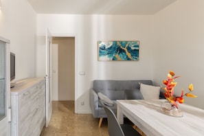 A modern room with a grey sofa, a wooden table, and a decorative vase.