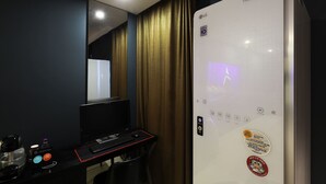 A hotel room with a bed, a desk with a computer, a coffee machine, and a TV. - Desing Hotel Vine (Ansan)