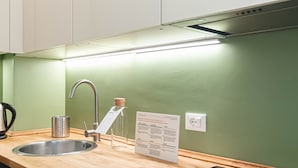A modern kitchen with a stainless steel sink, a kettle, and a glass pitcher. - Italianway Comfort - Salmini 1 (Milan)