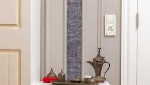 Ein kleiner, abgeschlossener Raum mit einem minikühlschrank mit Glastür, einer wandmontierten Steckdose und einem Regal mit Dekoration.