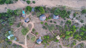 An aerial view of a resort with multiple dome-shaped structures, pathways, and scattered greenery.