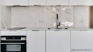 A modern kitchen with white cabinets, a marble backsplash, and stainless steel appliances. - Luxury Apt • AC • Workspace • 5 min to Downtown (Kraków)
