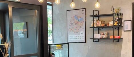 A modern interior with a seating area, a map on the wall, and a refrigerator with beverages.