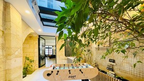 A foosball table in a modern indoor space with stone walls and a glass ceiling. - Loft Bordelais (Bordeaux)