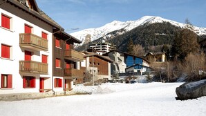 A snow-covered mountain town with multi-story buildings, balconies, and a ski lift. - Cornone Di Blumone A5 by Halldis (Ponte Di Legno)