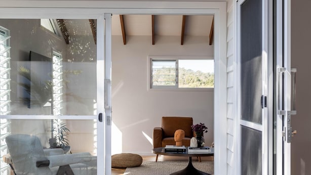 Un intérieur moderne avec une porte-fenêtre coulissante donnant sur une terrasse extérieure.