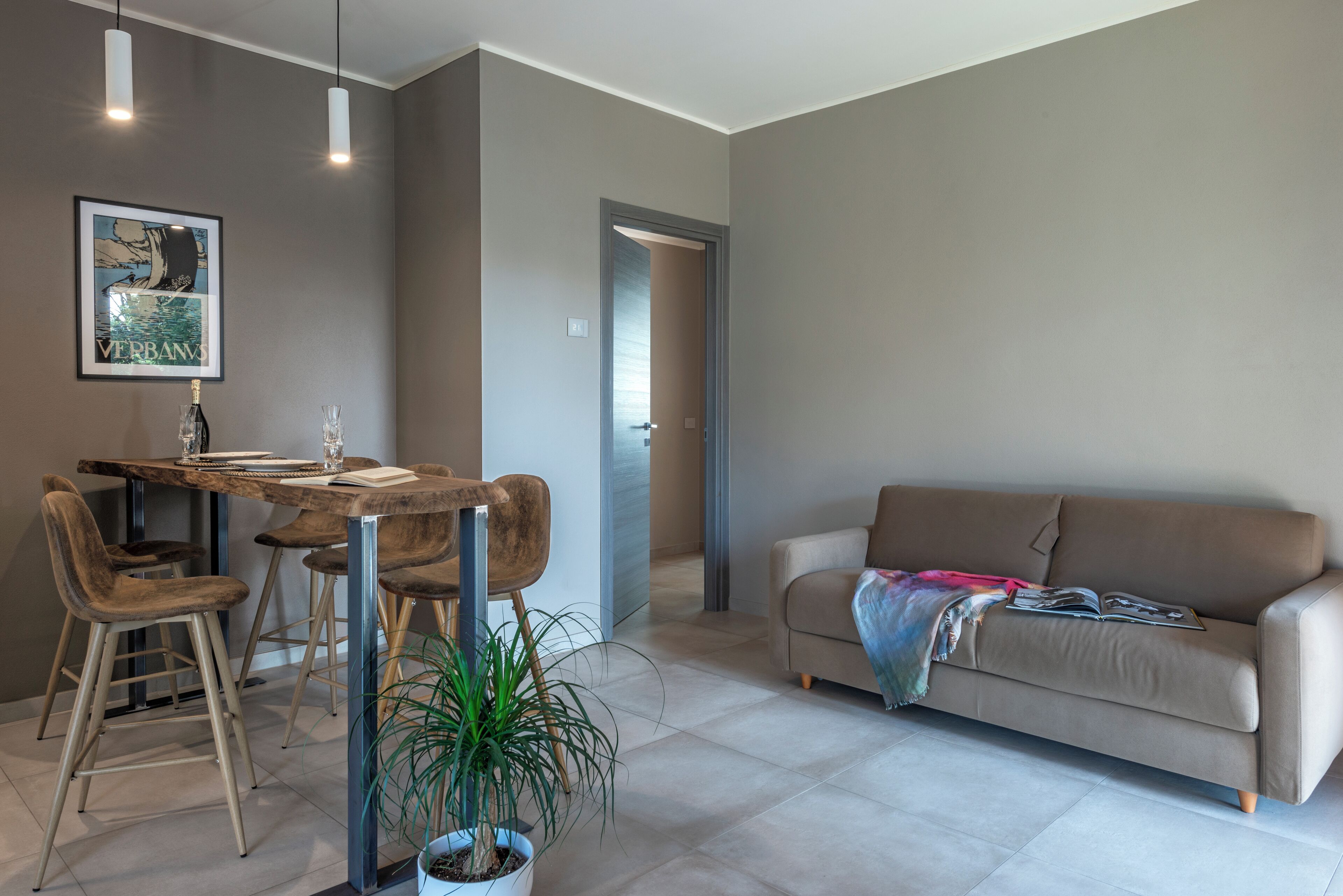 Un salon moderne comprenant un coin repas, un canapé et une plante en pot.