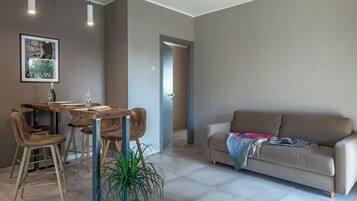 Un salon moderne comprenant un coin repas, un canapé et une plante en pot.