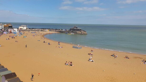 A beach with a pier extending into the water, surrounded by buildings and people. - Family Seaside Escape - Near Viking Bay (Broadstairs)