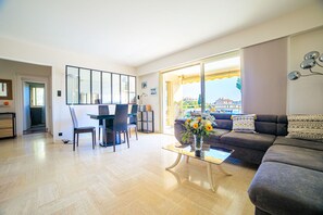 Relax in this stylish living room with a sofa, dining area, and large window offering a view of the outside.