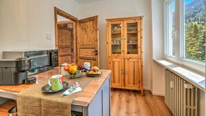 A compact kitchen with wooden cabinets, a microwave, and a fruit bowl on the counter. - Starkeeper Apartment Ski Base With Balcony Views (Pragelato)