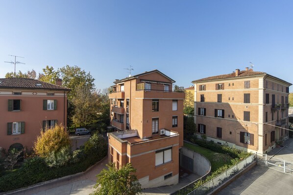 A residential building with multiple floors, balconies, and a clear sky.