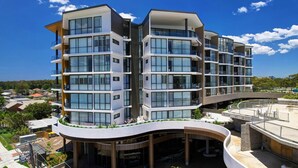 A multi-story modern building with balconies, large windows, and a curved rooftop terrace. - Solaris 610 overlooking the lake. (Forster)