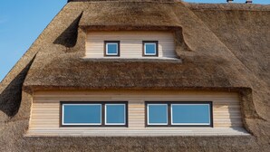 A building with a thatched roof and a small dormer window. - Herzlich Willkommen im Appartement Nepomuk (List auf Sylt)