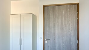 Een kamer met een kast en een houten deur.